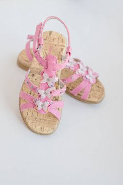 Beyaz bir arka plan üzerinde izole kelebek ile Pembe kız kız yaz sandalet. Yaz için trendy rahat ayakkabılar. Toddler moda parmak arası terlik. Sevimli bebek sandalet çifti.