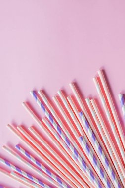 pembe arka planda çizgili ve polka nokta tasarım sınırı olan pipet ler. Minimalizm kavramı. Pop sanat tarzı. İçme suyu veya yumuşak için kullanılan kağıt pipetler