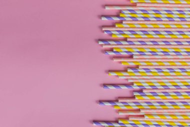pembe arka planda çizgili ve polka nokta tasarım sınırı olan pipet ler. Minimalizm kavramı. Pop sanat tarzı. İçme suyu veya yumuşak için kullanılan kağıt pipetler