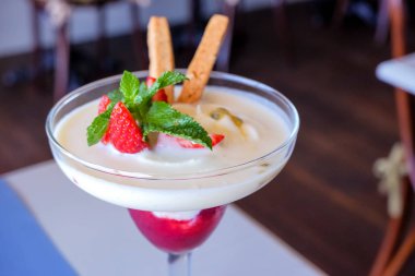 Yaz tatlısı, nane yaprakları. Berry tatlı ile süslenmiş çilek ile klasik cheesecake. Bir cam olgun çilek parçaları ile sağlıklı ve lezzetli yoğurt detoks Smoothie. Boşluk Kopyala