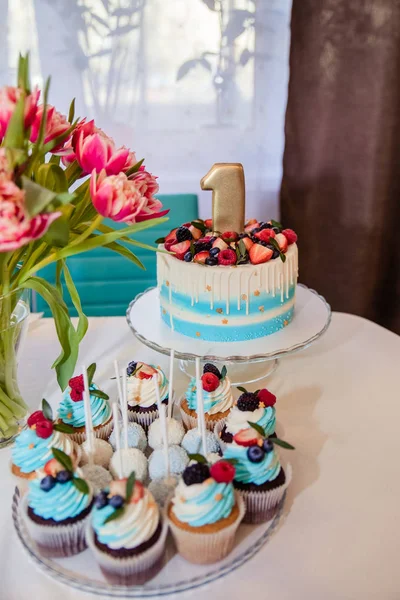 子供の誕生日のためのインテリア装飾は1歳です。カップケーキ、マカロン、花を使ったお祝いのテーブル。記念日デート1のお祝い。誕生日パーティー.バースデーケーキ、1と装飾 — ストック写真