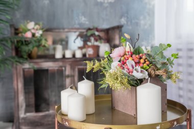 Masada organik mum var. Loft iç dekor, minimalizm kavramı. Closeup, yeşil yaprakları, çiçekler ve birçok beyaz mumlar ile eko ev dekor. Minimalist ev dekorasyonu.
