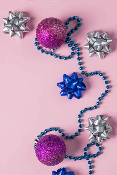 Růžové korálky a ornamenty na růžovém. Nový rok koule, konfety. Příprava na zimní prázdniny. Pohled shora. Minimální sváteční karta. stříbrná a modrá příď s dekorací a jiskři. Slavnostní koncept. — Stock fotografie