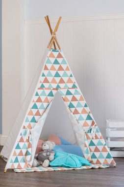 Dekorile dekoratif boho tarzı rahat kulübe. Wigwam odada, İskandinav tarzı, minimal ev iç tasarım.odada çocuk için çadır. Oyun çadırı ve oyuncaklar ile rahat çocuk odası iç