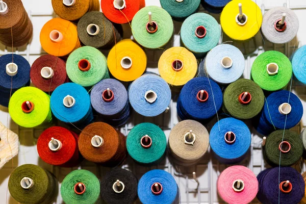 Vista superior variedad de carretes grandes y usados de hilos de costura de colores. Fondo tema tienda de sastrería, Textiles y concepto de la industria de la ropa. enfoque selectivo, espacio para el texto — Foto de Stock