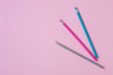 Renkli kalemler, pastel arka plan da izole.pembe kağıt üzerinde renkli kalemler arka plan. Çizim malzemeleri: çeşitli renk parlak kalemler.