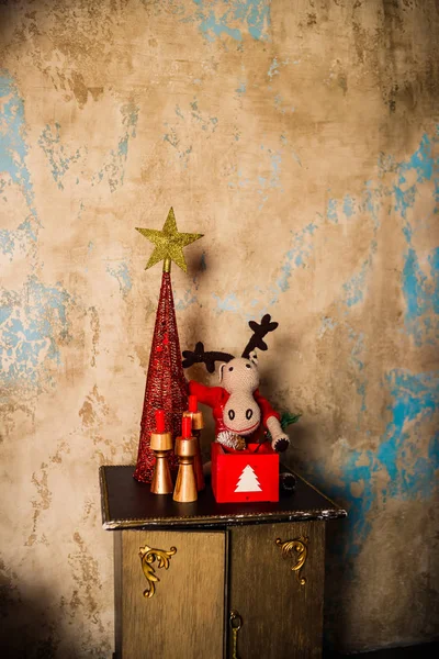 Decoração de casa de Natal minimalista simples. Decoração de Natal em fundo de parede marrom rústico, velas e um estilo de rena de brinquedo. Ambiente de férias de inverno. Estilo vintage — Fotografia de Stock