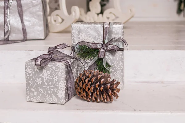 Pudełka na prezenty świąteczne i srebrne łuki na białym tle. Świąteka kartka z życzeniami. Opakowane pudełka na prezenty, ozdoby świąteczne. Koncepcja święta nowego roku. Ręcznie robione prezenty — Zdjęcie stockowe