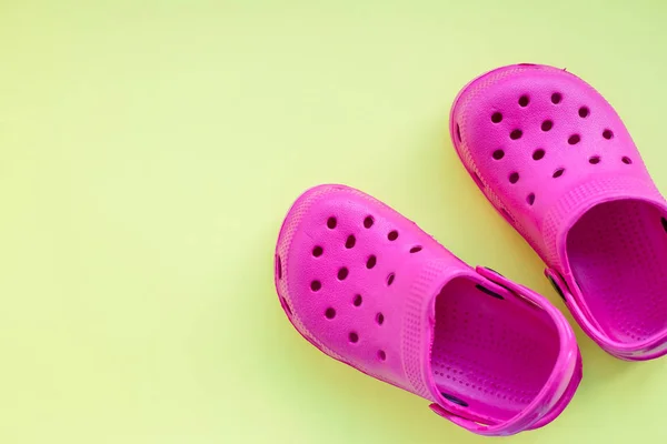 San Diego, USA, maj 10, 2019. Summer Pink flip flops isolerade på gul bakgrund. barn mjuka gummisandaler eller Crocs. sommarlov trendiga skor, sandaler. snygga barn sandaler. rosa skor — Stockfoto