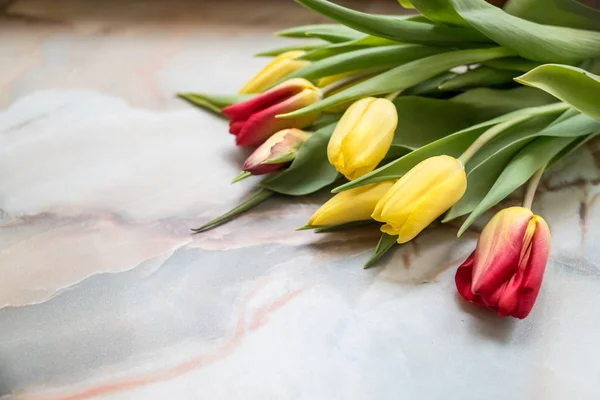 Schöne Tulpen zum Muttertag auf Marmorhintergrund, Seitenansicht. Internationaler Frauentag. Strauß schöner Frühlingstulpen. frische bunte Tulpenblumen auf Steintisch. — Stockfoto