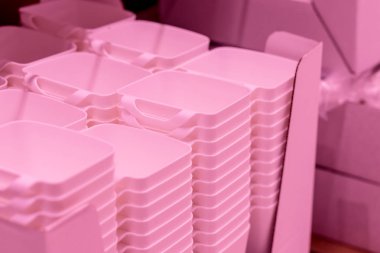 katlanmış pembe şeffaf plastik kaplar.plastik kaseler. Plastik gıda kapları, mağazada rafta sepetler