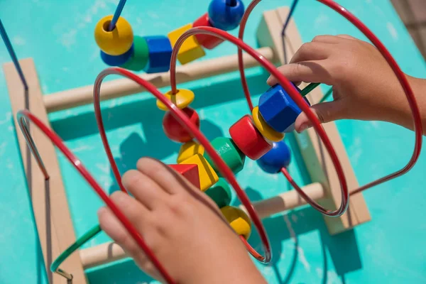 Kid playing with educational toy at home. little kid playing developing games for kids. Happy child playing colorful toys. Educational toy. Developing games.Wooden eco-friendly