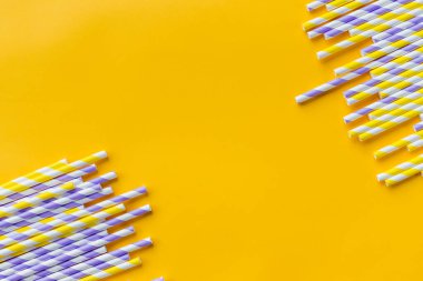 Kutlama şablonu düzleşmesi, bayram kutlamaları için kokteyl pipetleri. Tebrik kartı, tasarım. Eko, yeniden kullanılabilir, kağıt, şeritli kamış, sarı arka planda meyve suyu ya da kokteyl içmek için.