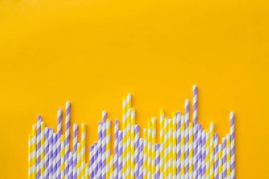 Sarı arka planda saman içen beyaz şeritli kağıt sırası. Doğum günü partisi bebek partisi davetiyesi eğlenceli çocuklar tatil konsepti. Minimalist stili. Boşluğu kopyala