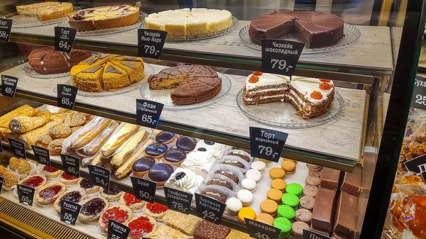 Moscow, Russia, May 17, 2020. Cakes on the shelves of a window of a street restaurant. Showcase of a pastry shop or cafe with lots of sweets and price tags.Fresh delicious sweet cakes — Stock Photo, Image