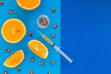 Ampuller ve vitamin C.organik kozmetik konseptli Serum. mavi arka planda turuncu, mandalina ve kozmetik ampuller. Deri yüz ve vücut sağlığı hizmetleri. Nemlendirici, detoks tedavisi, stres önleyici etki..