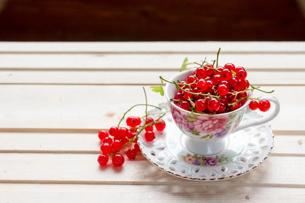 Fresh red currants in a cup on wooden table close up .Ripe large organic red currant .Summer fresh berries.agriculture and food concept — стоковое фото