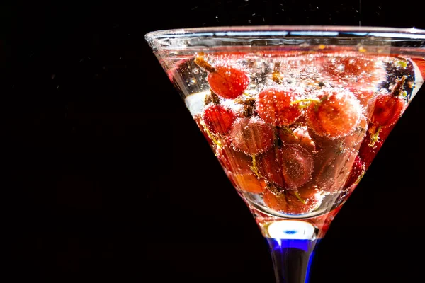 Copo de bebida refrescante fria do verão com bagas e cubos de gelo na mesa close up. refrescante bebida de verão com groselha espinhosa . — Fotografia de Stock