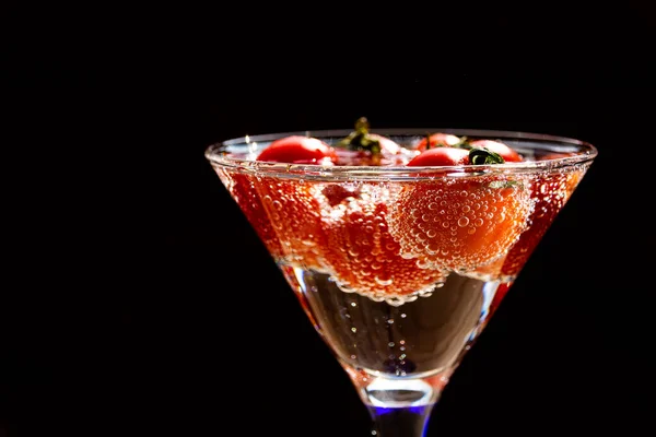 El tomate flota en agua con burbujas en vidrio de vidrio sobre fondo blanco . — Foto de Stock