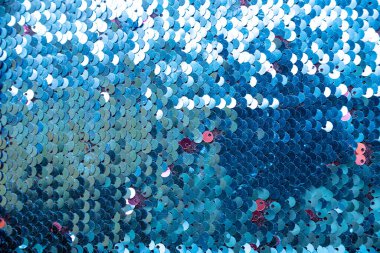 mavi ışıltılı arka plan. Pırıl pırıl pullar. Parlak dokular. Arka plan. Pul olarak kumaşa dikilmiş bir sürü mavi renkli pullar..