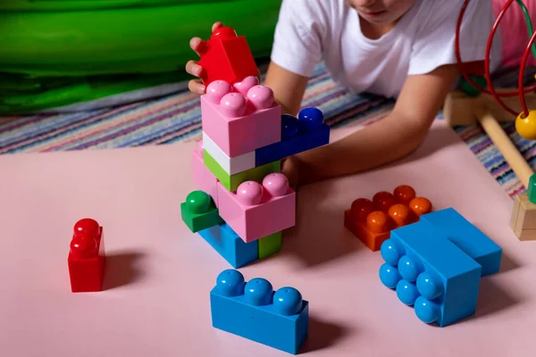 Lchild playing with construction toy blocks, building a tower in kindergarten. Children at day care. Child and toys.Educational toy for preschool and kindergarten child.Development Concept — Stock Photo, Image