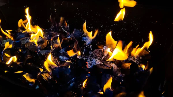 Charbons chauds dans le feu.braises brûlantes activement du feu.Brûlage du bois de chauffage dans la cheminée fermer, BBQ fire.black charbon de bois brûlé — Photo