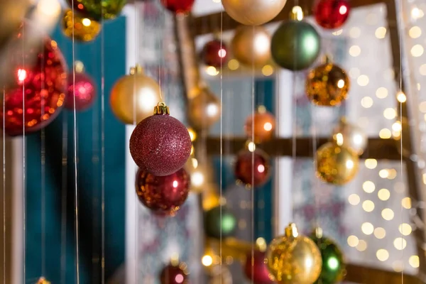 Новогоднее украшение. Художественная инсталляция "Рождественская елка", выполненная со строчными огнями и рождественскими шарами, висящими на нитях. Выборочный фокус. Рождественское оформление. Творческий, современный и стильный декор. — стоковое фото