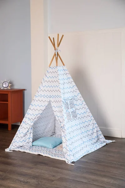 Odada oyuncakları olan çocuk kulübesi. Çocuk odasının içinde çocuklar için çadır kulübesi var. Boho tarzında oyunlar, çocuk odasının içi çok aydınlık. Wingwamwam tarzında.