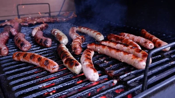 Smaczne soczyste kiełbaski grillujące przy ognisku.Food and Drink koncept.BBQ z ognistymi kiełbaskami na grillowym pikniku na świeżym powietrzu. Soczyste i dobrze grillowane kiełbaski.grill, uliczne jedzenie, festiwal żywności. — Zdjęcie stockowe