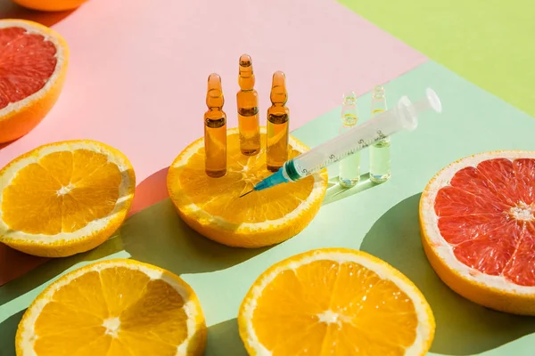 Yüksek dozda C vitamini, şırınga ve taze meyve slaytları enjekte etmek için ampul. Vitamin, mineral takviyesi, güzellik ürünü. Organik Doğal Kozmetik Konsepti.