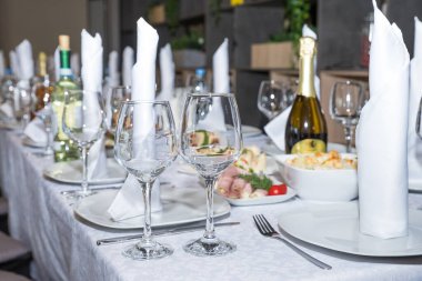 Restoranda boş bardaklar var. Ziyafet masasına servis edilmiş. Peçeteli, bardaklı ve salamlı şarap bardakları. Yemek servisi geçmişi, atıştırmalıklar ve barmen tezgahında şarap bardakları.