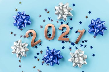 2021 altın figürler ve renkli yıldızlar, mavi arkaplanda konfeti. Mutlu yıllar. Altın numaralar, tatil geçmişi, kartpostal, parti.