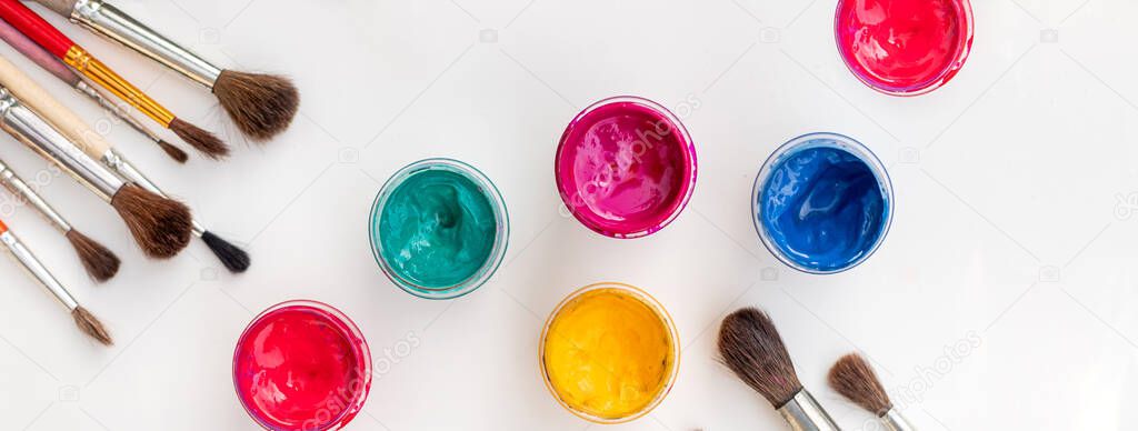 Open jars with gouache of different colors and brushes.hobby painting . Learning to draw. Paints gouache. Childrens creativity.advertisement, advertising