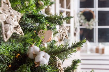 Ahşap kalbi, meleği, çamı, köknar ağacı dalları ve pamuğu olan şık bir Noel ağacı. Kuru Pamuk Çiçekleri, Noel Çam Ağacı Süslemeli Parlayan Lambalar, Süsler. İçi rahat. Çevre dostu materyal.