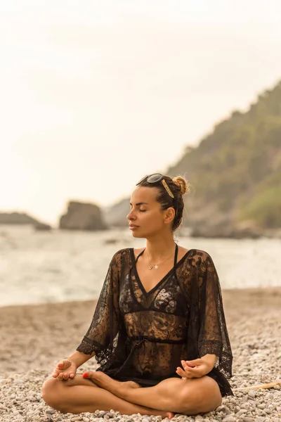 Kobieta Sobie Czarne Koronkowe Tunika Medytacji Pięknej Zatoce Ujęcie Pionowe — Zdjęcie stockowe