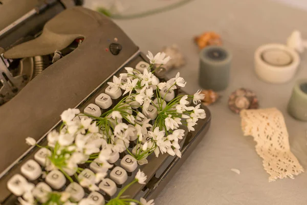 Spring or summer writing concept. Vintage typerwriter with flowers between keys