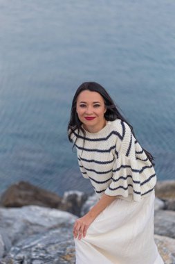 Deniz tarzı kıyafetler içinde deniz kenarı kadın