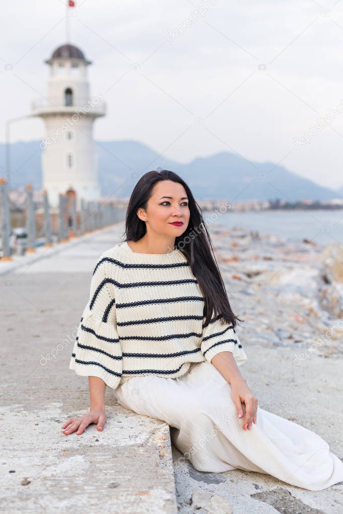 Solo female traveller sitting near the lighthouse