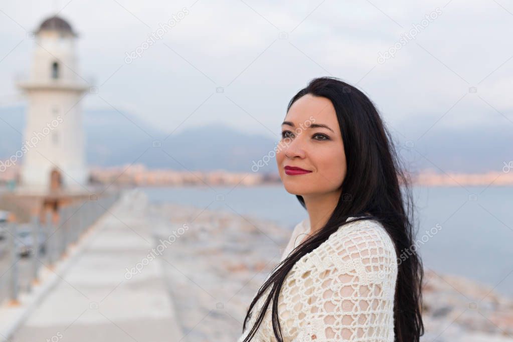 Portrait of beautiful romantic female near the lighthouse