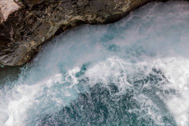 Kayalar ve köpük ile Fırtınalı deniz suyu yüzeyi. 