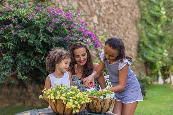 Zeit im Freien verbringen. Mutter mit ihren Kindern beim Blumenschneiden — Stockfoto