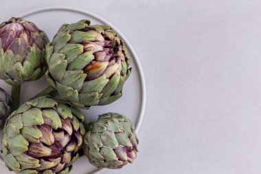 Açık gri arkaplandaki enginarların üst görünüm resmi.