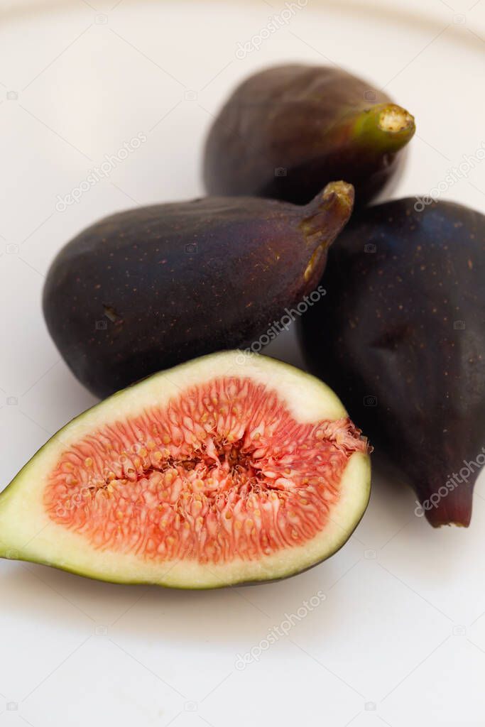 Minimalistic image of figs in white ceramic plate.