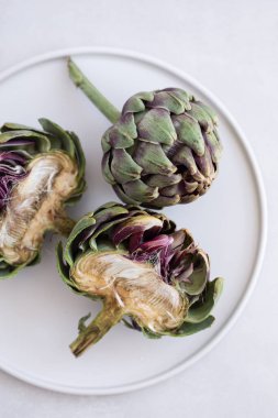 Beyaz seramik tabakta enginarların üst görünümü.