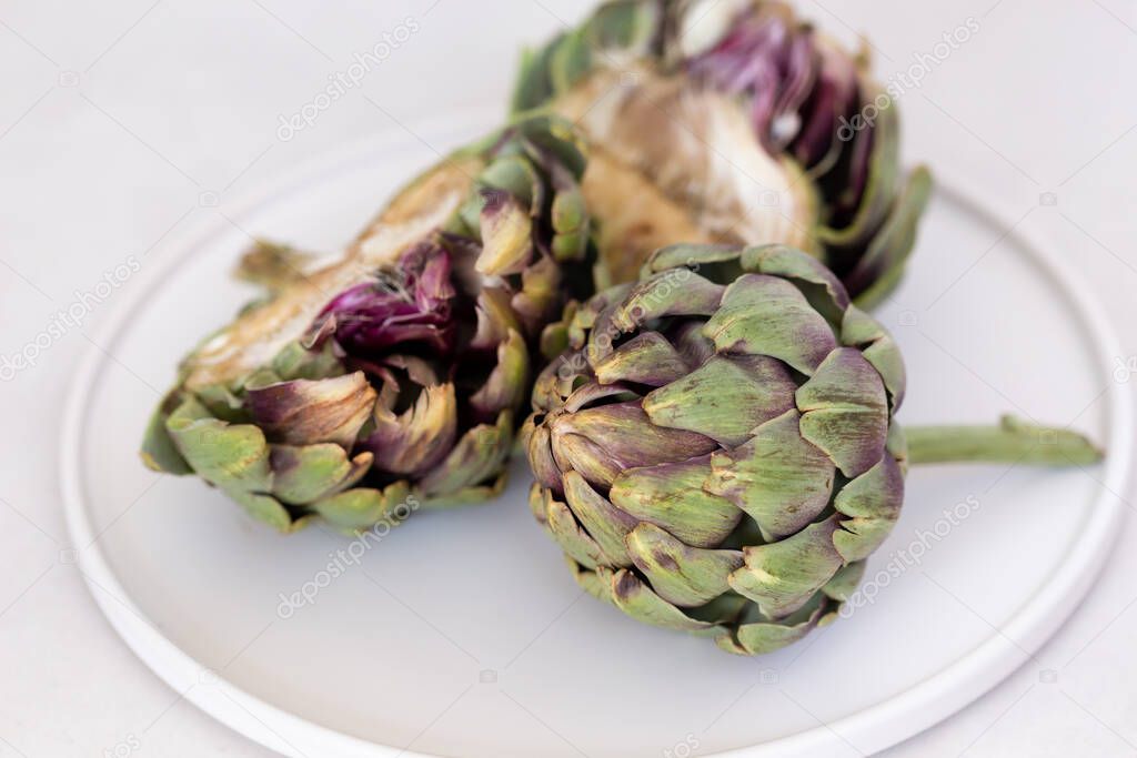 Artichokes in a white ceramic plate.