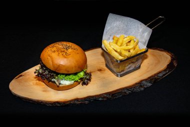 Patates kızartmasının yanında taze salatayla dolu leziz bir ızgara çizburger. 