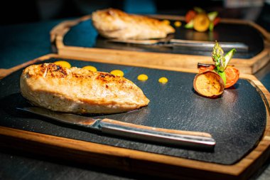 Kesme bıçakları ve garnitürleriyle müşterilere servis edilen ızgara tavuk göğsü seçimi. 