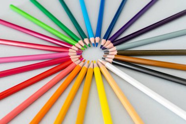 Renkli kalemlerden oluşan bir spektrum bir daire şeklinde bir masanın üzerine yerleştirilmiş.