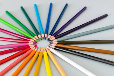 Renkli kalemlerden oluşan küçük bir spektrum bir daire şeklinde bir masanın üzerine yerleştirilmiş.