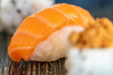 Mavi seramik tabakta servis edilen taze suşi ruloları. Yakın plan. 